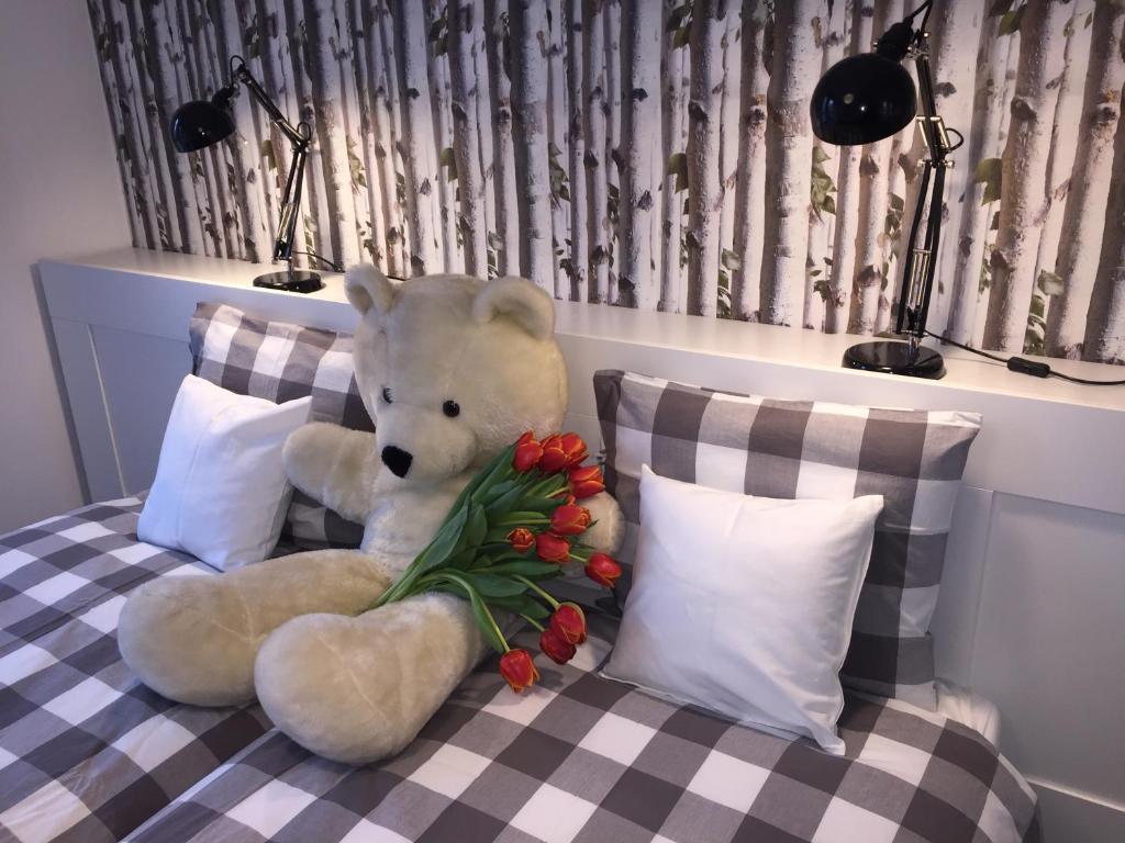a large white teddy bear sitting on a bed at Chillout Polna - Parking in Poznań