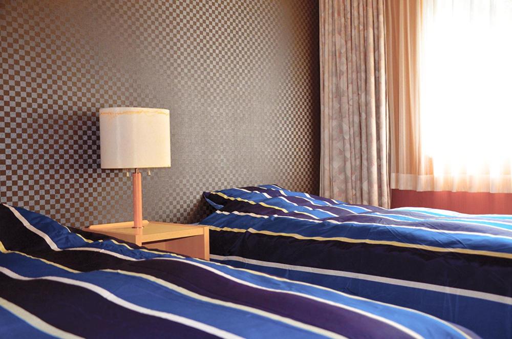 Postel nebo postele na pokoji v ubytování Hotel Bauhinia ホテルバウヒニア