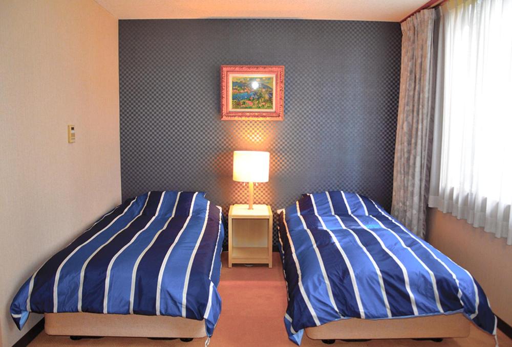Postel nebo postele na pokoji v ubytování Hotel Bauhinia ホテルバウヒニア