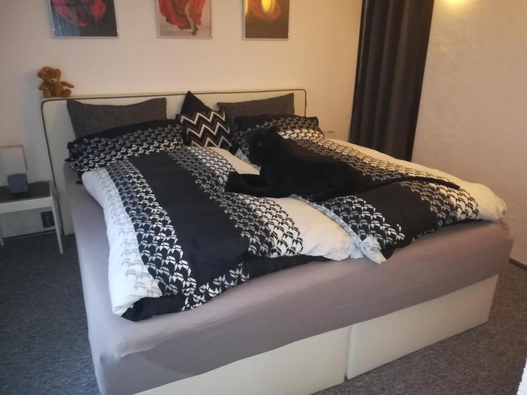 a bed with black and white pillows on it at Haus Chrissy in Altmünster