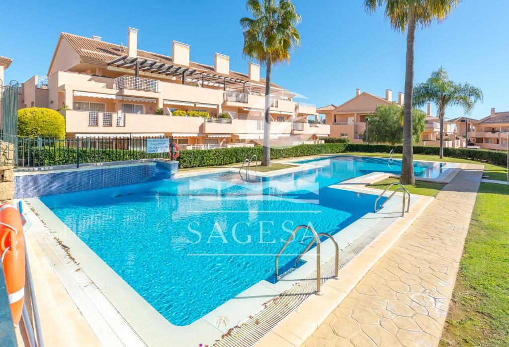 una piscina en una villa con palmeras en Los Jardines de Santa Maria Golf, en Marbella