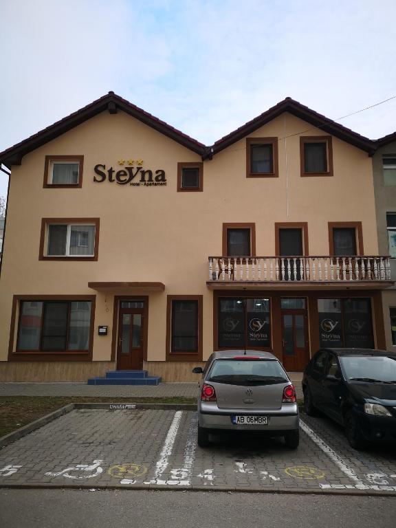 a building with a car parked in front of it at Camere-Apartament Steyna in Alba Iulia