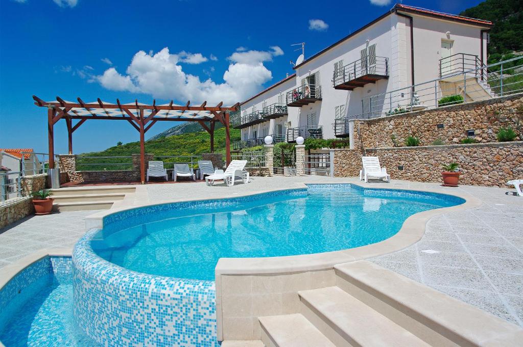 una piscina frente a una casa en Villa Lara Apartments en Bol