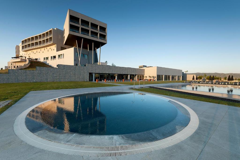 uma grande piscina de água em frente a um edifício em Hotel Casino Chaves em Chaves