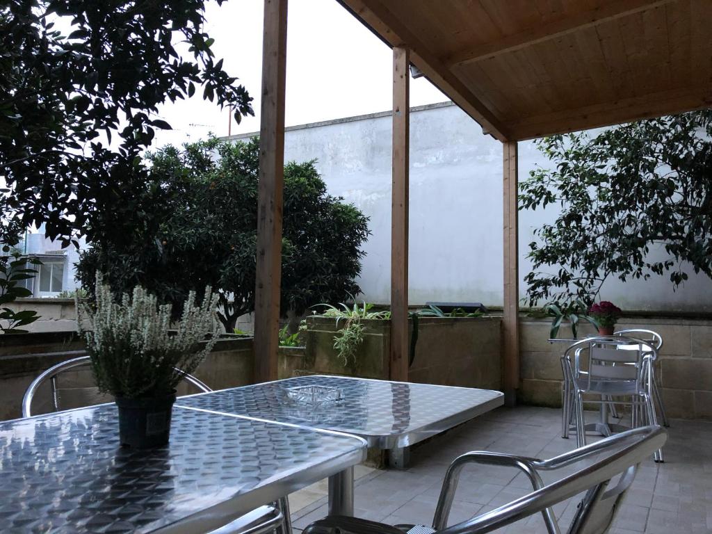 カヴァッリーノ・ディ・レッチェにあるMonterussi Bed and Breakfastのガラスのテーブルと椅子が備わるパティオ