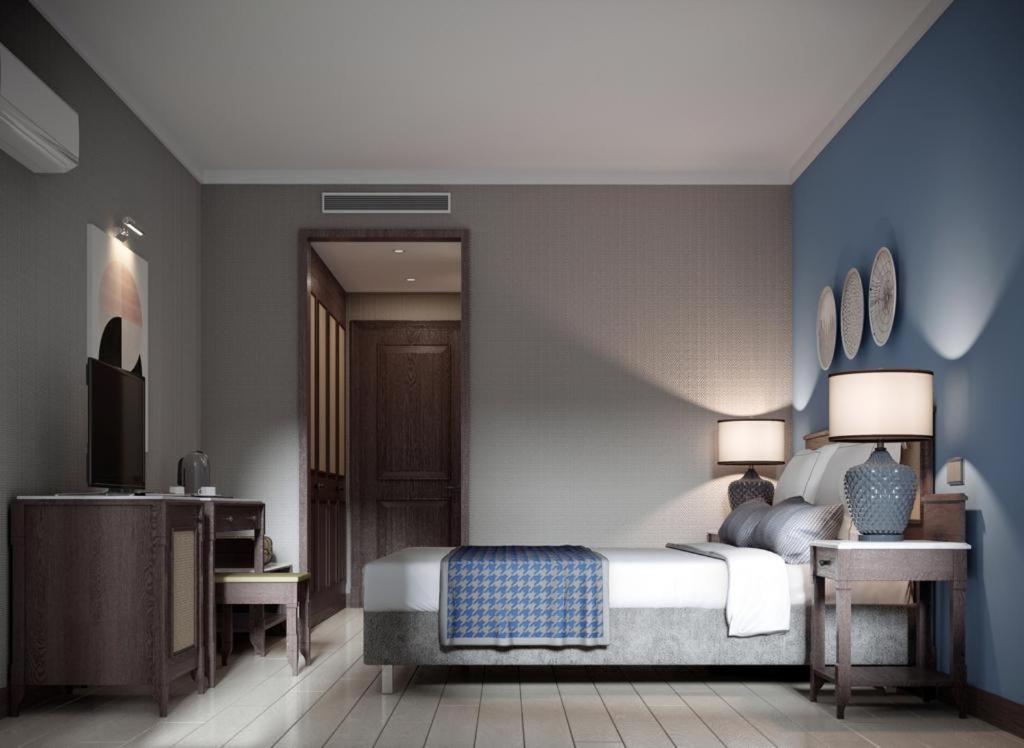 a bedroom with a bed with a blue wall at Lara Park Hotel in Antalya