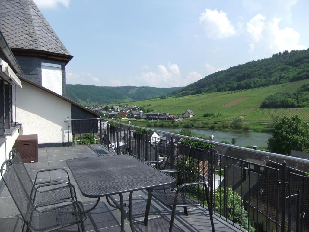 a balcony with a table and chairs and a river at Ferienwohnung Morgen in Valwig