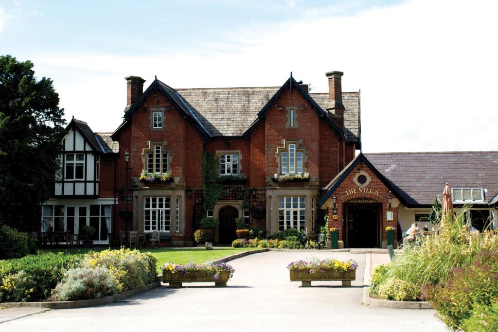 a large red brick house with a driveway at The Villa Country House Hotel in Wrea Green