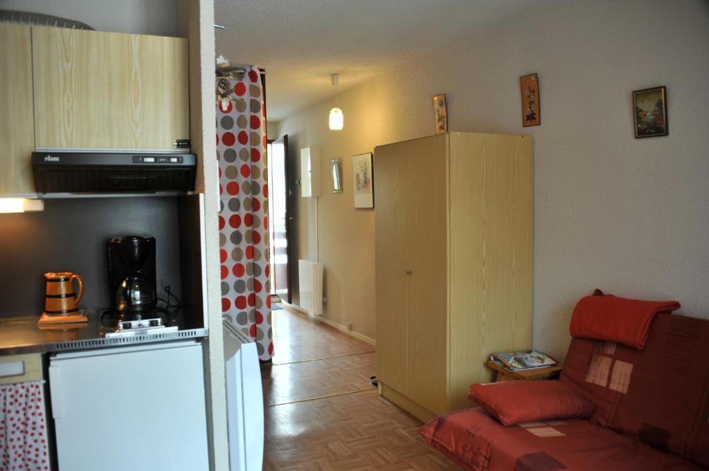 eine Küche und ein Wohnzimmer mit einem Sofa und einem Kühlschrank in der Unterkunft Résidence les Bords du Lac in Le Lauzet-Ubaye