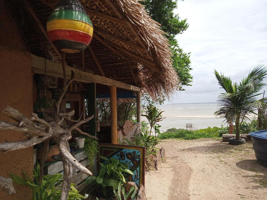 a building with a thatch roof and a large colorful light at La Luna Fortalezinha in Algodoal