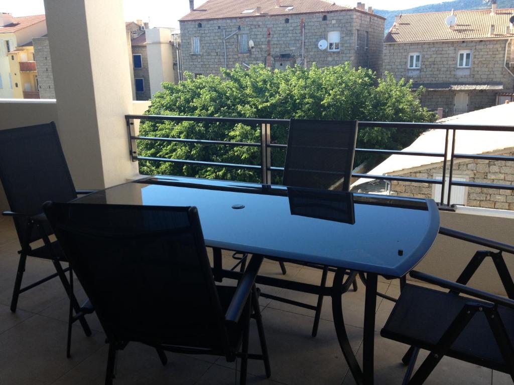 une table bleue et des chaises sur un balcon dans l'établissement Appartements Porto-Piano, à Propriano