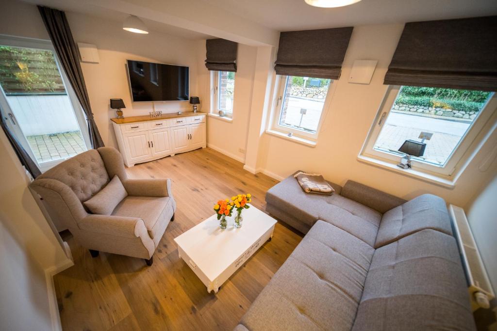 a living room with a couch and a table with flowers at Duenenschloss in Westerland (Sylt)