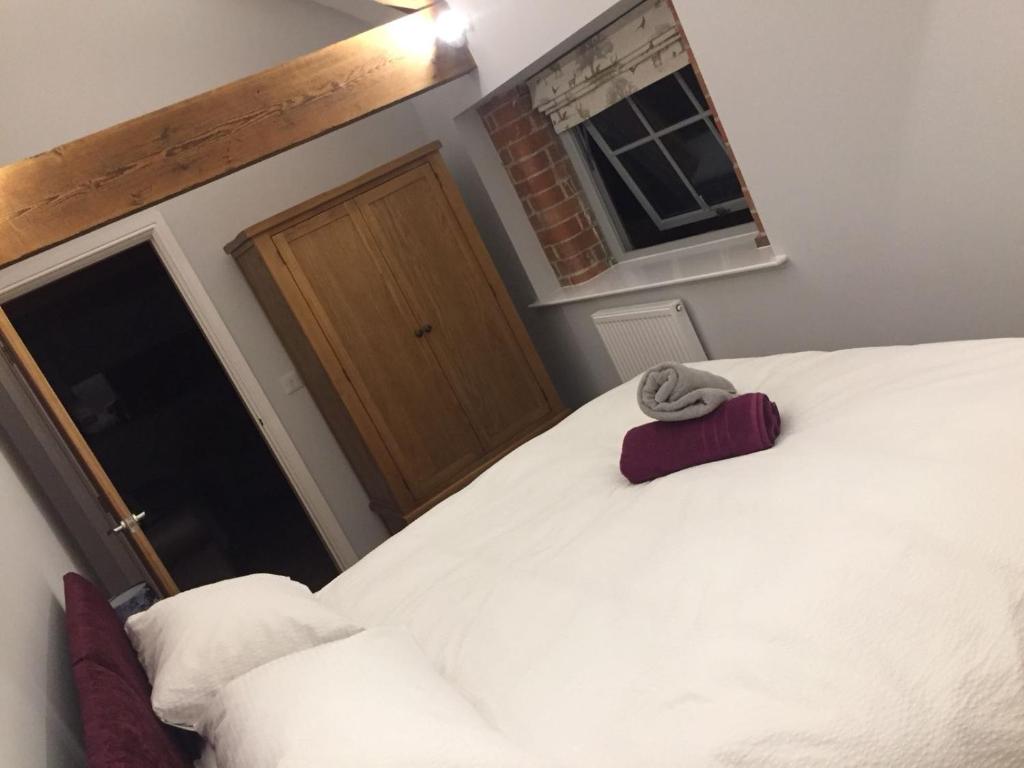 een slaapkamer met 2 witte bedden en een raam bij Rolling Mill, Wolds Way Holiday Cottages, 2 Bed, 1st floor in Cottingham