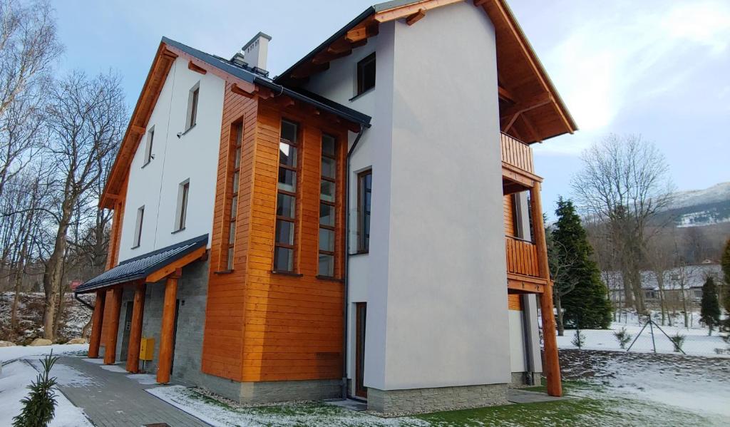 ein Haus mit Weiß und Orange in der Unterkunft Apartamenty EverySky - Emilii Plater 18-18A in Karpacz