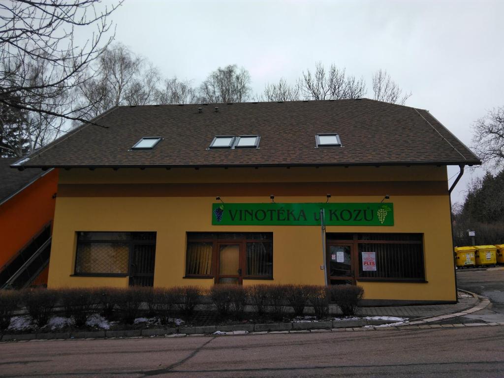 Ein gelbes Gebäude mit einem Schild, das Frauen liest. in der Unterkunft Vinotéka "U Kozů" in Neustadt an der Mettau