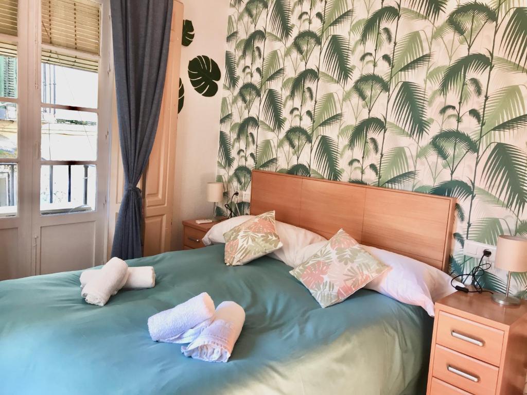 マラガにあるAPARTAMENTUM Ballesteros Málagaのベッドルーム1室(ベッド1台、タオル2枚付)