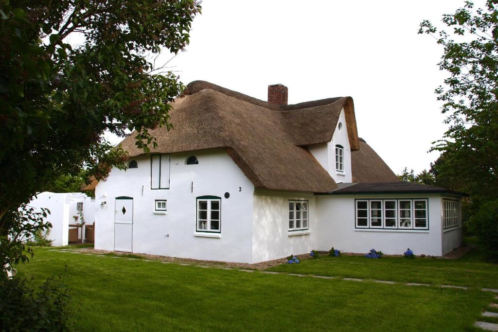Casa blanca con techo de paja en Friesenhaus Amrum Friesenhaushälfte *Hommelkasche* en Süddorf
