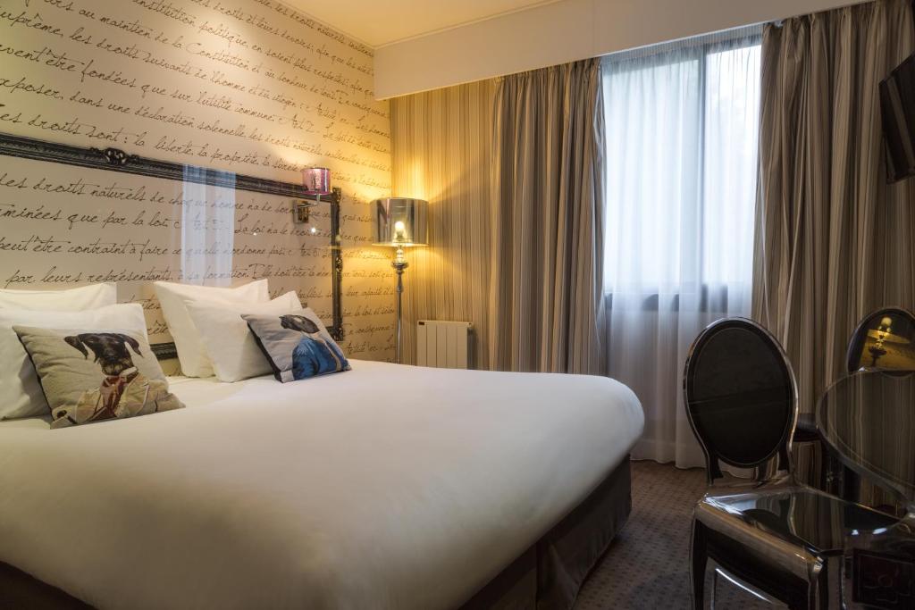 a hotel room with a large bed and a window at Hotel Albert 1er in Rueil-Malmaison