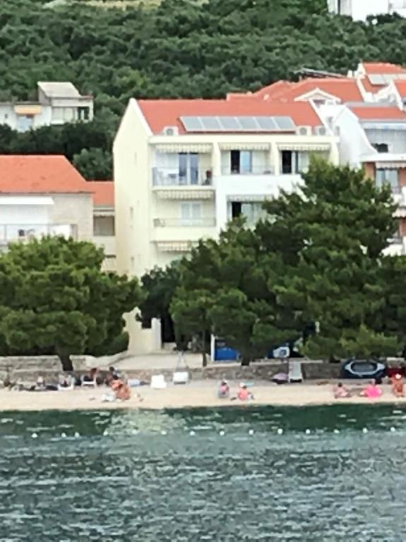 a group of people on a beach in front of a building at Vila Snježana Tučepi in Tučepi
