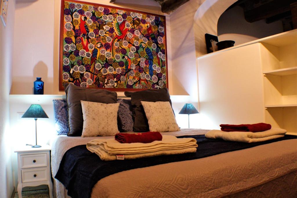 a bedroom with a bed with a painting on the wall at Il nido nascosto in Lucca