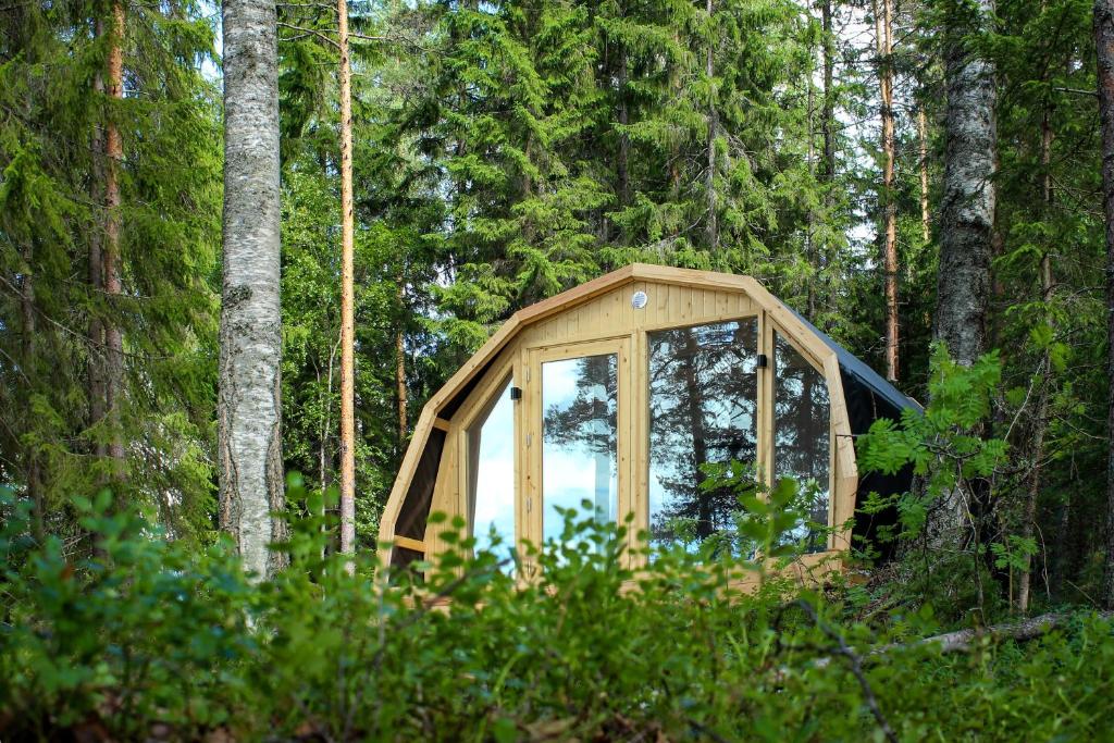 a wooden cabin with a mirror in the woods at Hidden House Pirttijärvi in Jämsä