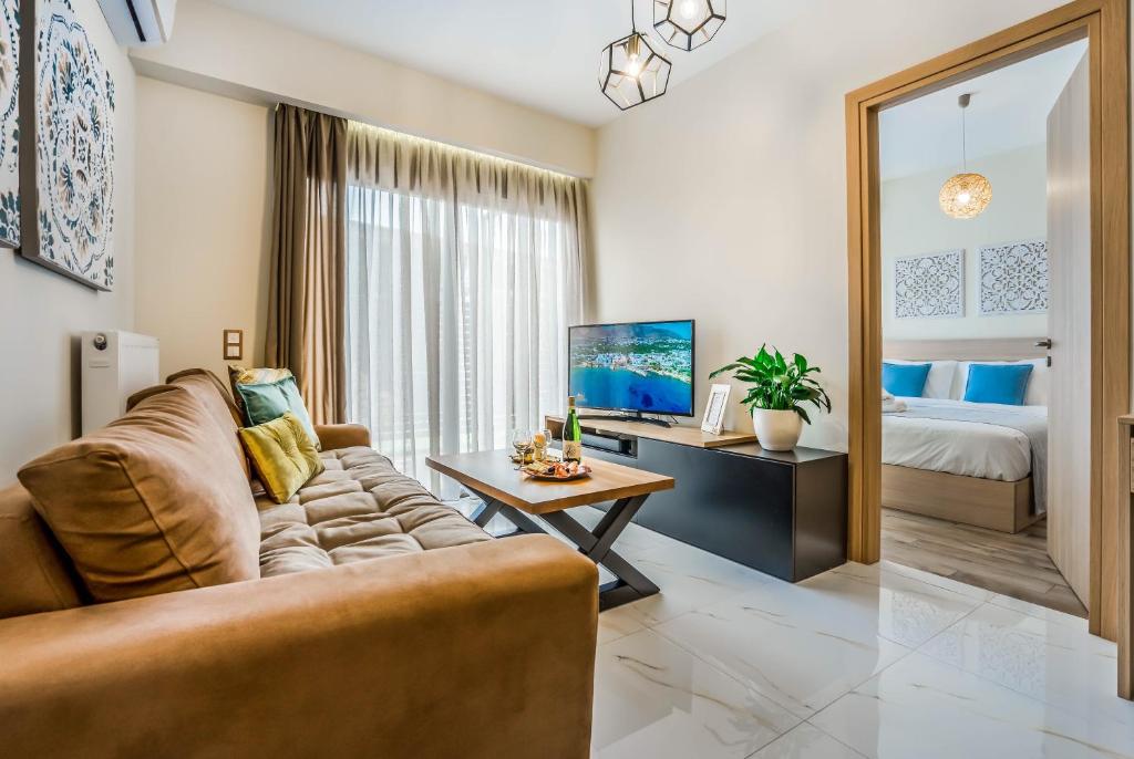 a living room with a couch and a tv and a bed at Lemar Luxury Apartments in Hersonissos