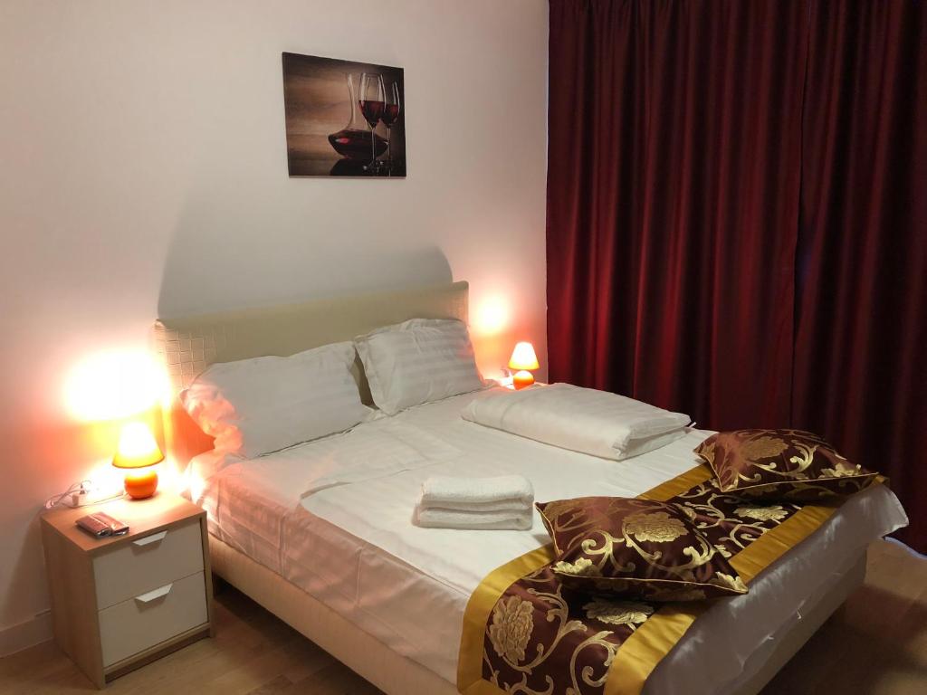 a small bedroom with a bed with two lamps on it at Upground Apartments in Bucharest