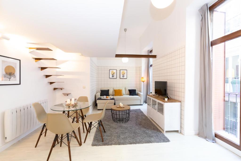 a living room with a table and chairs and a couch at Apartamentos Puerta Del Sol I in Madrid