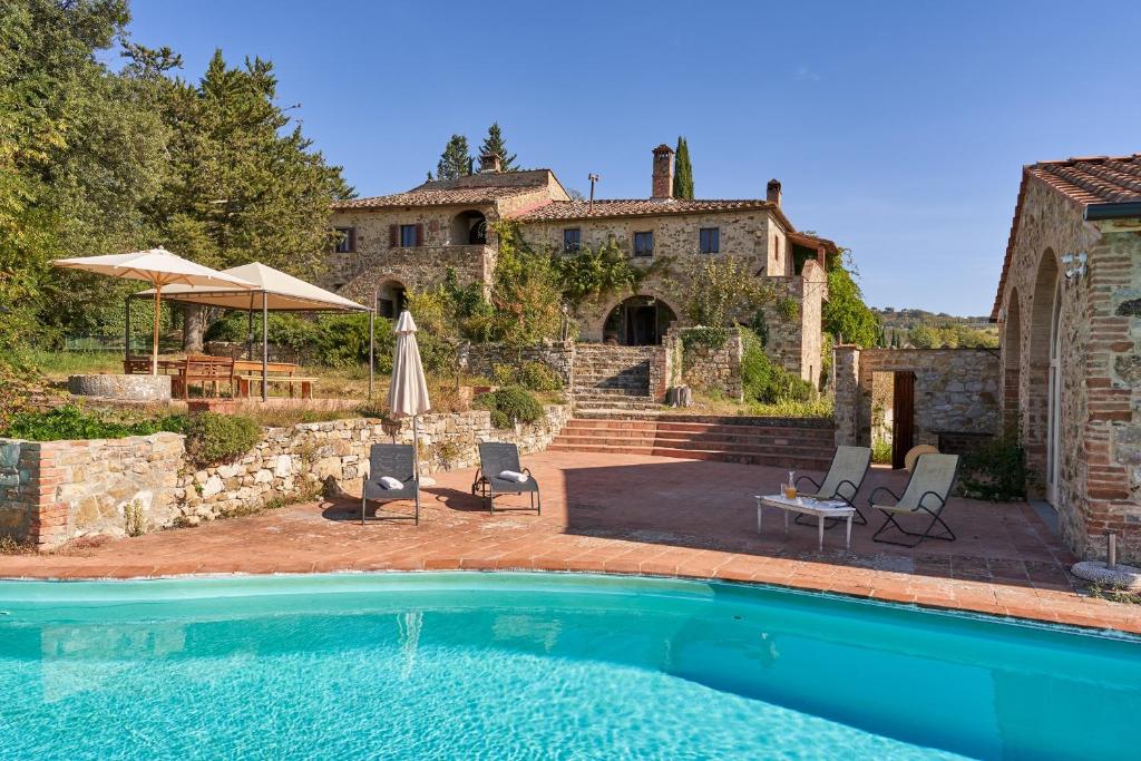 uma piscina em frente a uma casa em Casale Sandonatino by VacaVilla em Castellina in Chianti