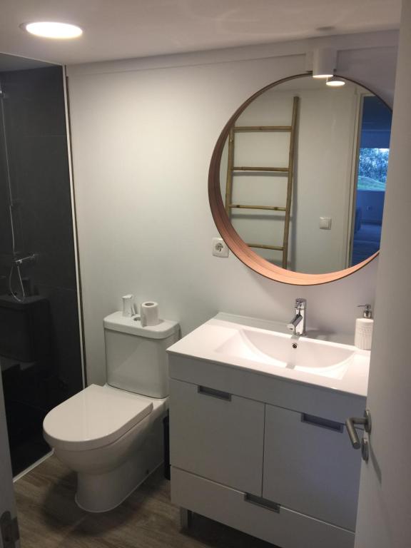 a bathroom with a toilet and a sink and a mirror at Quinta do Meco - Beach & Nature in Aldeia do Meco