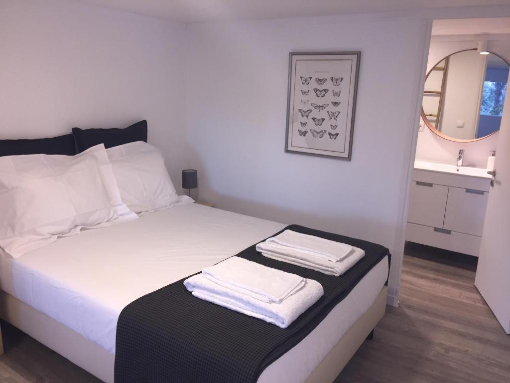 a bedroom with a bed with two towels on it at Quinta do Meco - Beach & Nature in Aldeia do Meco