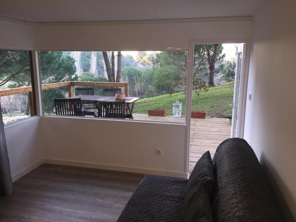 a living room with a couch and a large window at Quinta do Meco - Beach & Nature in Aldeia do Meco