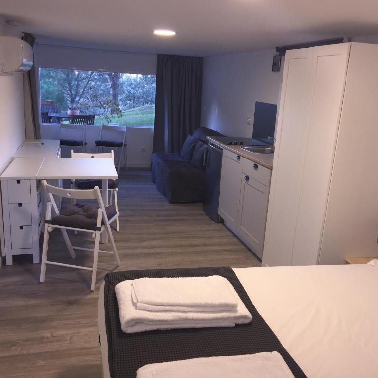 a dorm room with a kitchen and a table with a desk at Quinta do Meco - Beach & Nature in Aldeia do Meco