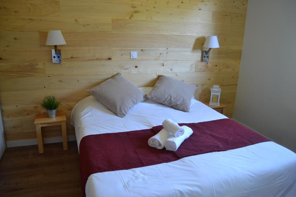 ein Schlafzimmer mit einem Bett mit zwei Handtüchern darauf in der Unterkunft Village de vacances Les Lambrilles in La Bastide-de-Sérou