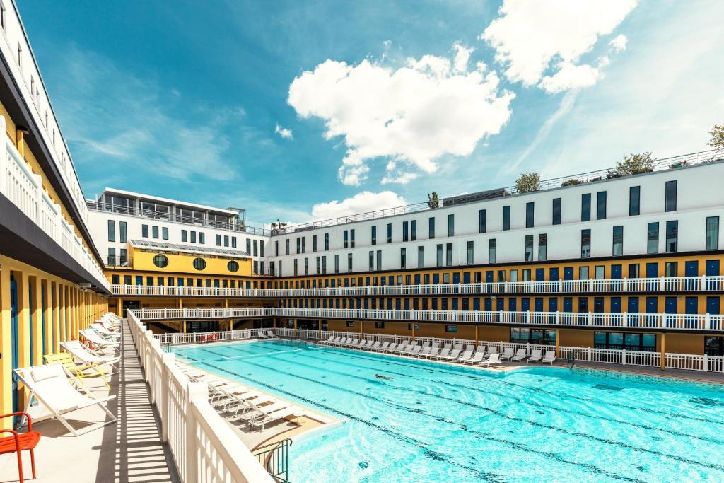 a large swimming pool in front of a building at Molitor Paris - MGallery Hotel Collection in Paris