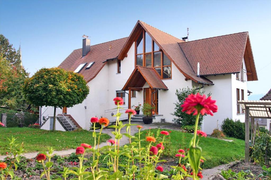 Haus Widenhorn في سيبلينغين: منزل أبيض مع زهور حمراء في الفناء
