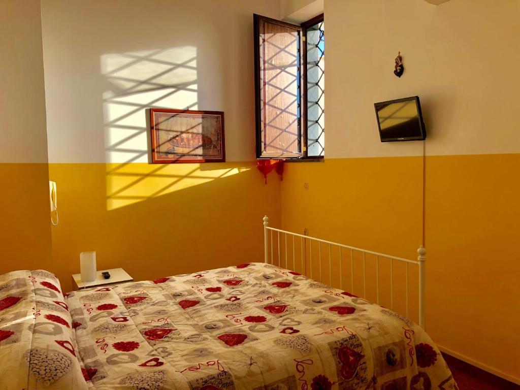 エルコラーノにあるB&B Real La Favoritaのベッドルーム1室(花柄のベッドカバー、窓付)