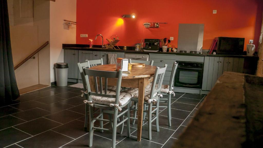 eine Küche mit einem Holztisch und Stühlen in der Unterkunft La Thébaïde in Saint-Amour