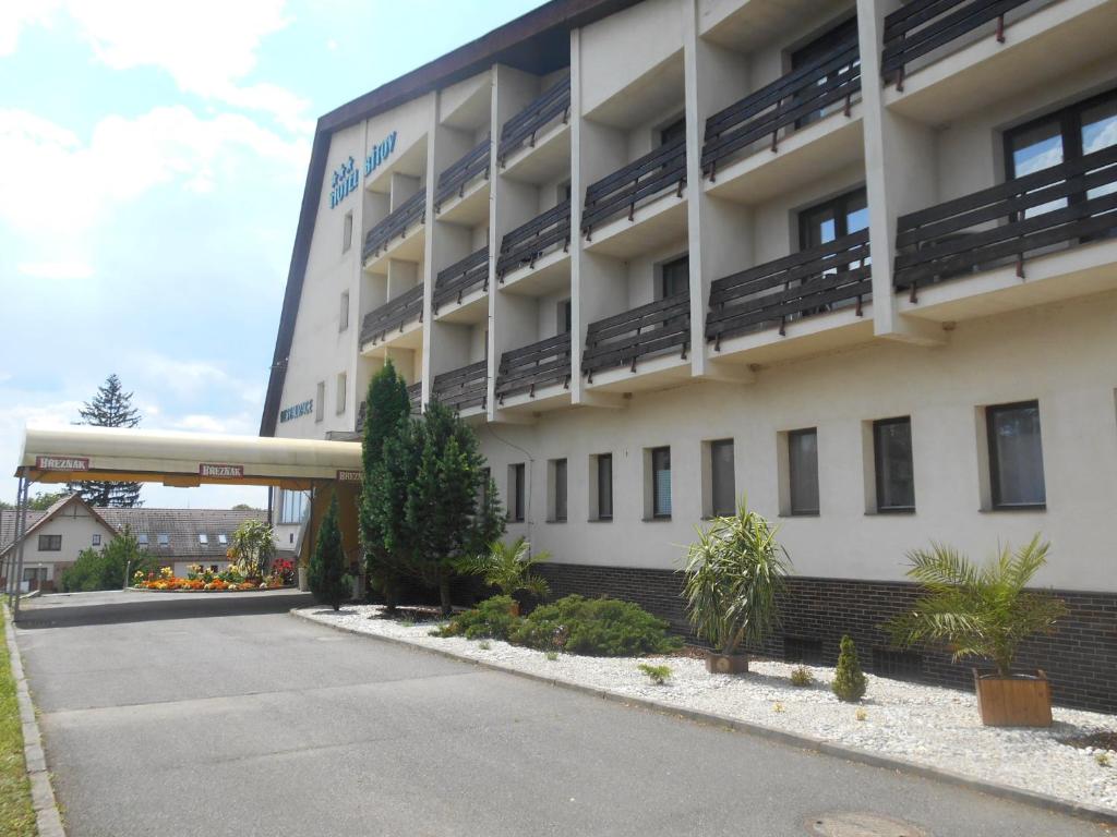 a large building with a parking lot in front of it at Hotel Bitov in Bítov