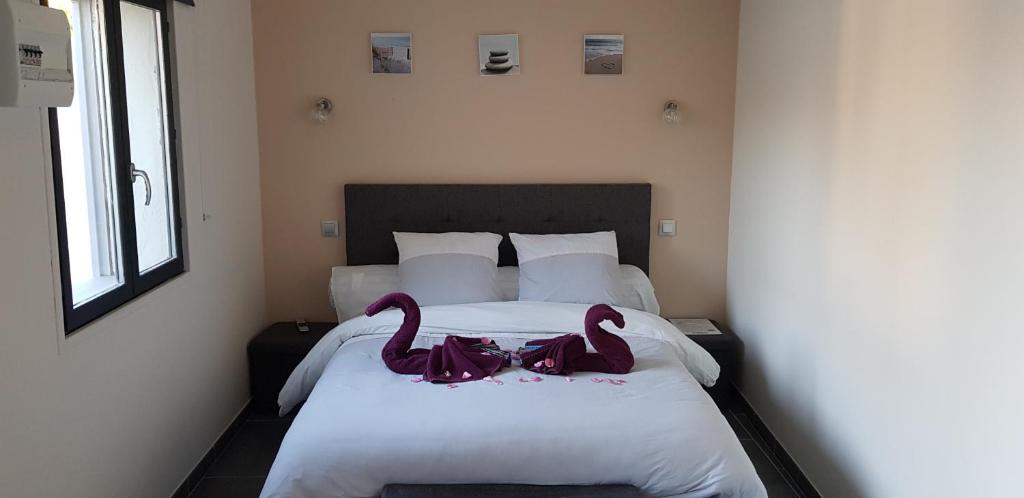 twee roze zwanen op een bed in een slaapkamer bij BAIE DE SOMME - Le pourquoi pas in Le Crotoy