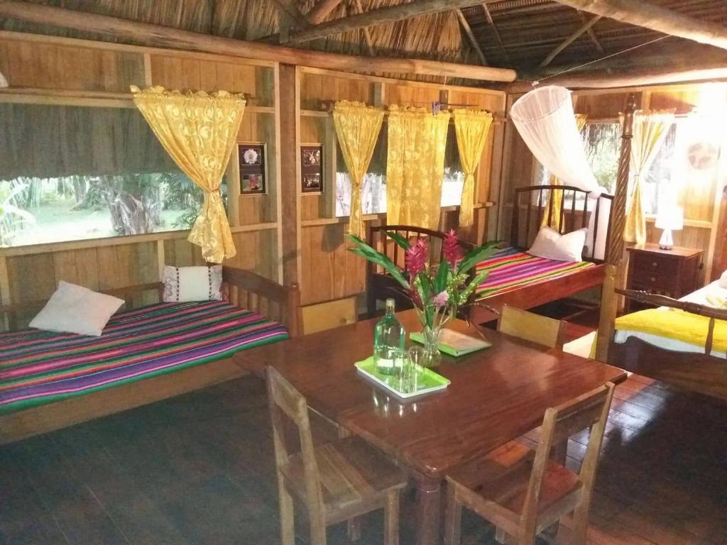 ein Wohnzimmer mit einem Tisch und 2 Betten in der Unterkunft Sun Creek Lodge in Punta Gorda