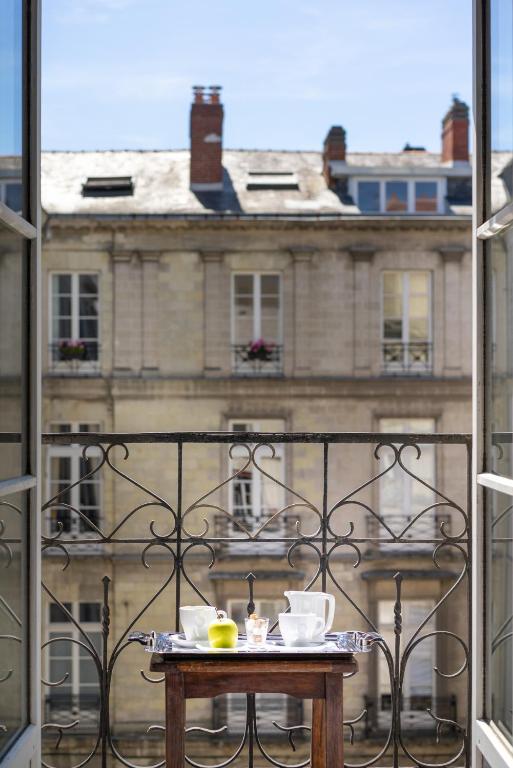 a table on a balcony with a view of a building at Hotel Voltaire Opera Nantes Centre in Nantes