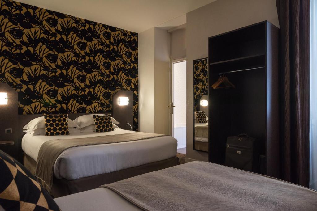 a bedroom with two beds and a black and gold wallpaper at Hotel Voltaire Opera Nantes Centre in Nantes