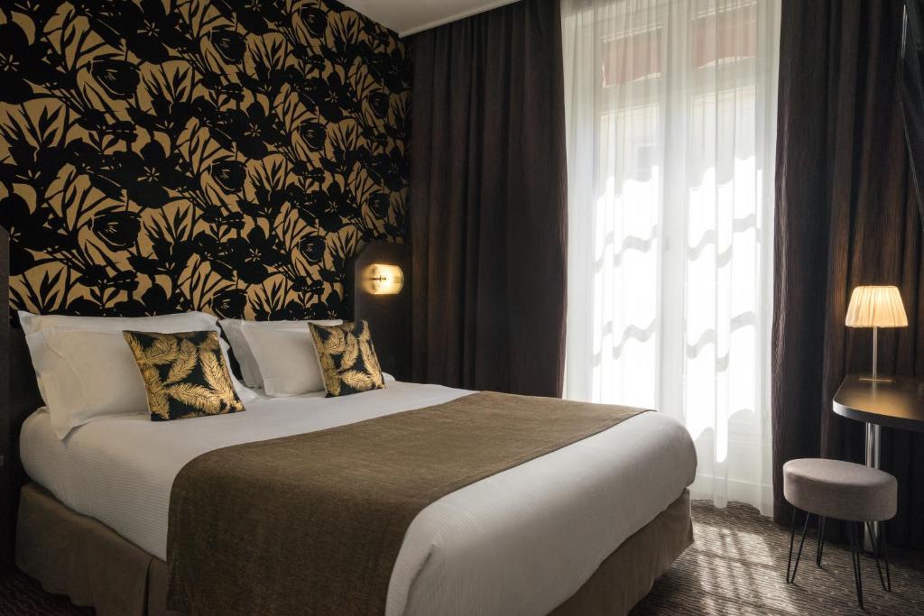 a bedroom with a bed with a black and gold wallpaper at Hotel Voltaire Opera Nantes Centre in Nantes