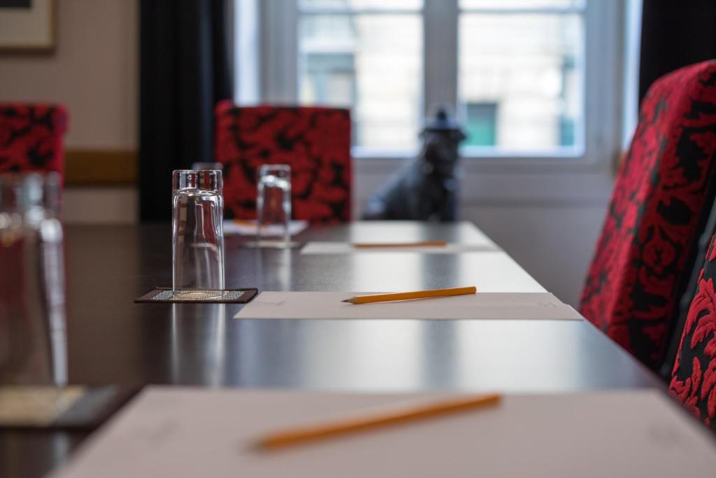 a table with red chairs and a table with a napkin at Hotel Voltaire Opera Nantes Centre in Nantes