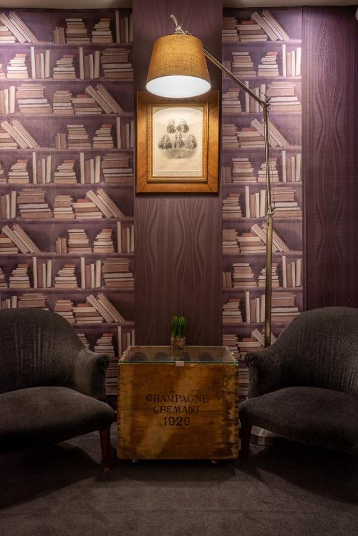 a room with a table and two chairs and a lamp at Hotel Voltaire Opera Nantes Centre in Nantes