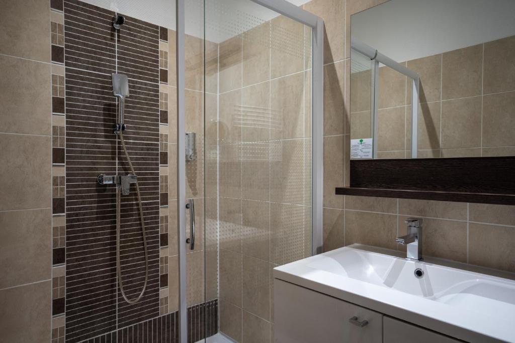 a bathroom with a sink and a shower at Hotel Voltaire Opera Nantes Centre in Nantes