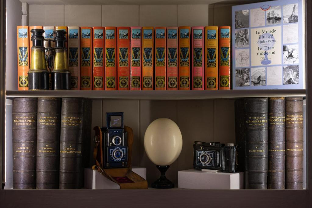 a shelf filled with books and a bunch of other books at Hotel Voltaire Opera Nantes Centre in Nantes