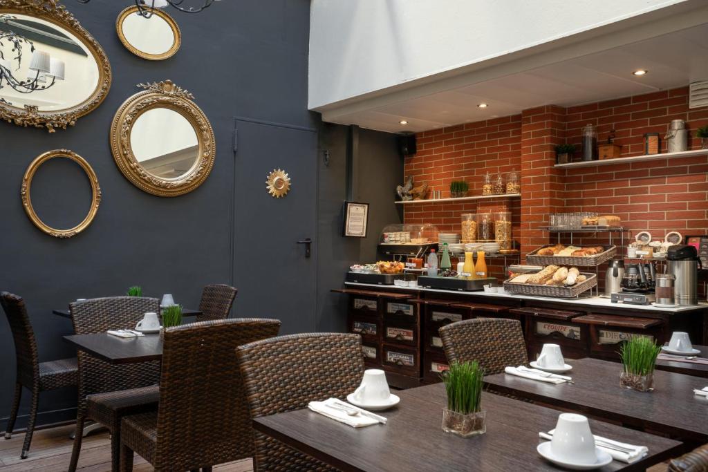 a restaurant with tables and chairs and a counter at Hotel Voltaire Opera Nantes Centre in Nantes