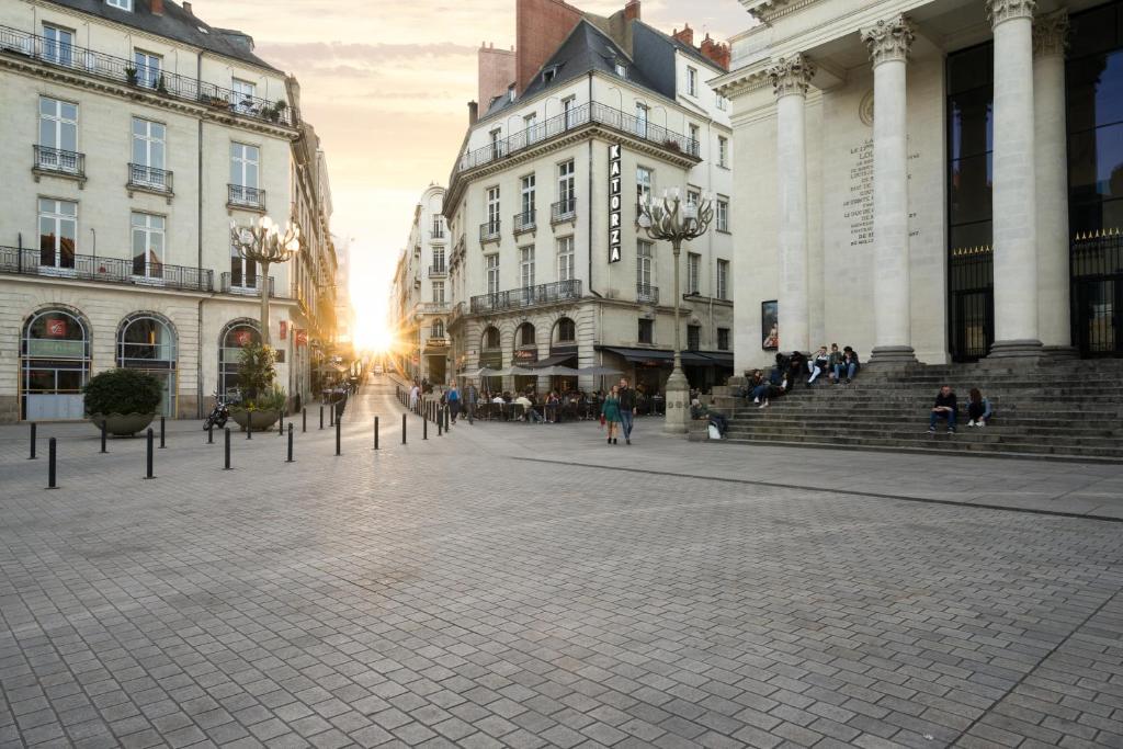 a city street with buildings and people walking around at Hotel Voltaire Opera Nantes Centre in Nantes